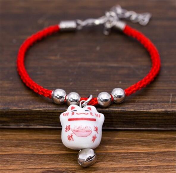 Pendentif porte-bonheur japonais illustrant le maneki neko